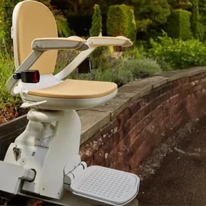 A Brooks 140 Outdoor Stairlift - New is installed along an outdoor staircase with a brick wall and greenery, providing accessible mobility.